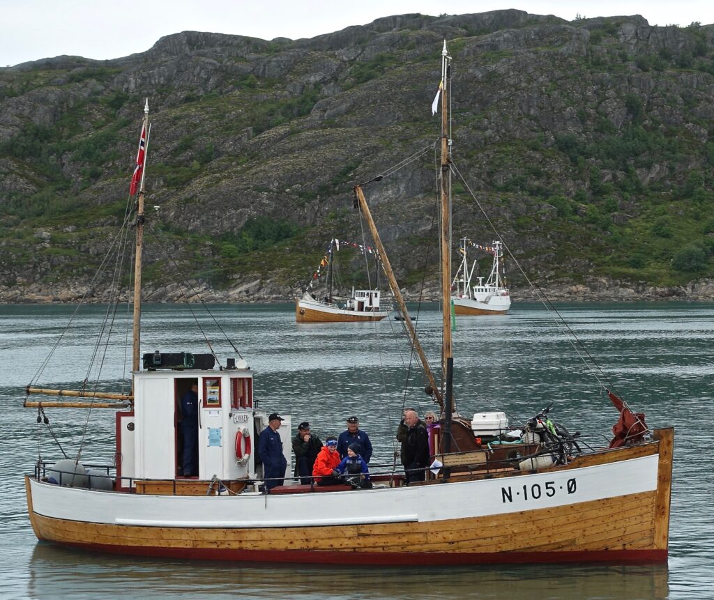 Heder i Bodø. Vi er på Forbundet Kystens landsstevne den 16.juli 2016. M/K «Lykken» har midlertidig forlatt sin hedersplass, 1A på indre havn, for å lede defilering av en gruppe spesielt utvalgte veteranbåter. Foto: Halvard Toften.