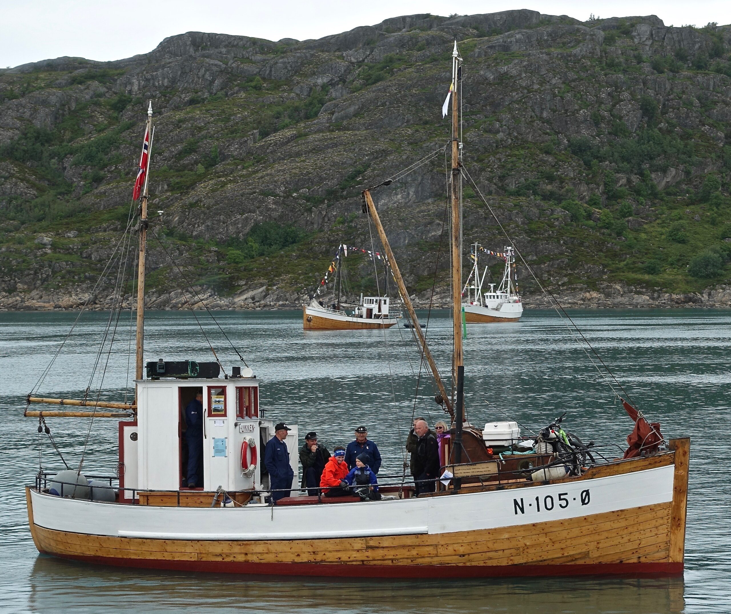 Heder i Bodø. Vi er på Forbundet Kystens landsstevne den 16.juli 2016. M/K «Lykken» har midlertidig forlatt sin hedersplass, 1A på indre havn, for å lede defilering av en gruppe spesielt utvalgte veteranbåter. Foto: Halvard Toften.
